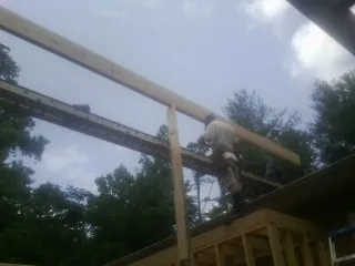 Carpenter setting a ridge beam over a new addition frame — Ice Dam Removal by Roofing Brothers in Gibbsboro