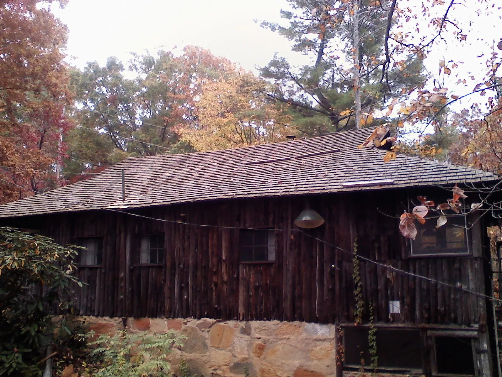 Weathered wood shake roof on a rustic board sided cabin in Gibbsboro
