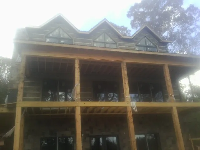 Dormers and porch framing on a large log home under construction — Roof Coating work by our crew in Gibbsboro